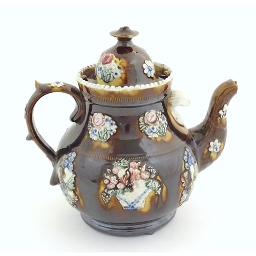 179 - A Victorian treacle glazed bargeware teapot with applied floral decoration and a banner for Mary Fen... 