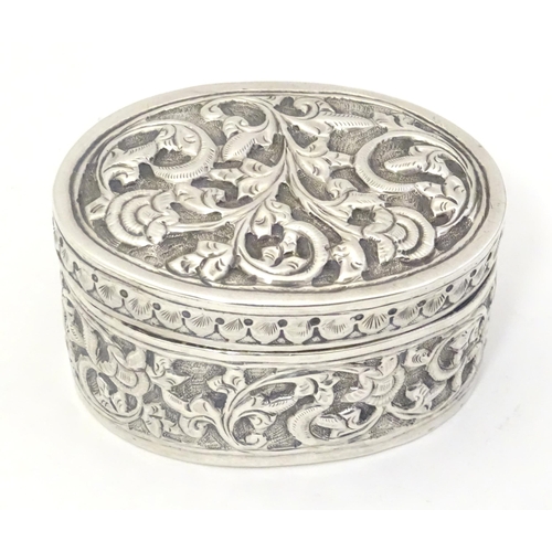 372 - A Continental white metal pot and cover of oval form with embossed decoration. Approx. 2 1/4