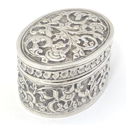 372 - A Continental white metal pot and cover of oval form with embossed decoration. Approx. 2 1/4