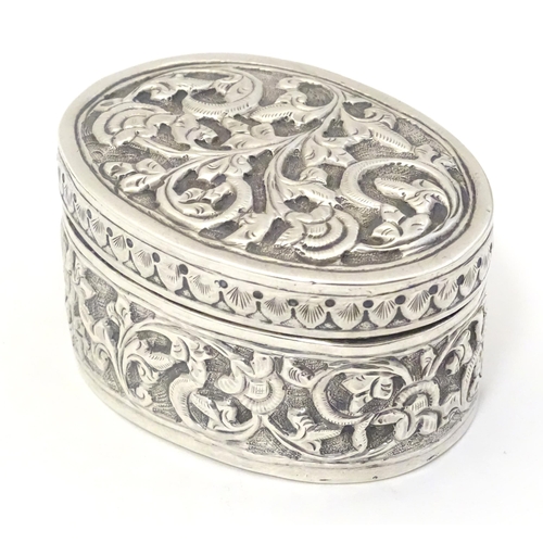 372 - A Continental white metal pot and cover of oval form with embossed decoration. Approx. 2 1/4