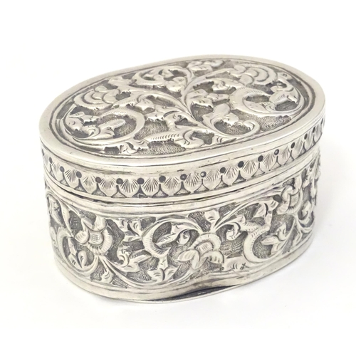 372 - A Continental white metal pot and cover of oval form with embossed decoration. Approx. 2 1/4