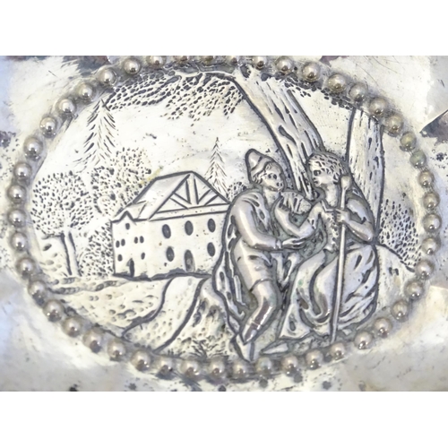 492 - A Continental silver dish of lobed form with twin handles and embossed decoration. Indistinctly mark... 