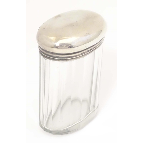 495 - A glass dressing table jar of oval form with facet detail and silver top hallmarked London 1921 make... 