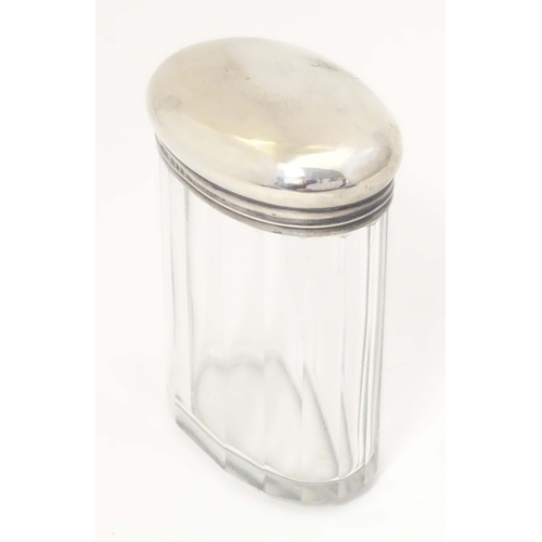 495 - A glass dressing table jar of oval form with facet detail and silver top hallmarked London 1921 make... 