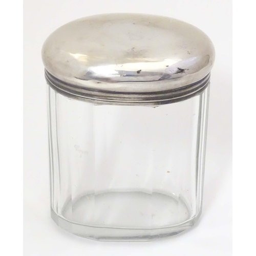 495 - A glass dressing table jar of oval form with facet detail and silver top hallmarked London 1921 make... 