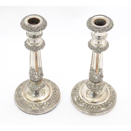 545A - A pair of silver plate candlesticks with acanthus scroll decoration. Approx 9