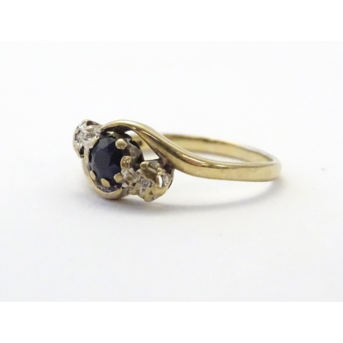 585 - A 9ct gold ring set with central blue spinel flanked by diamonds. Ring size approx. N