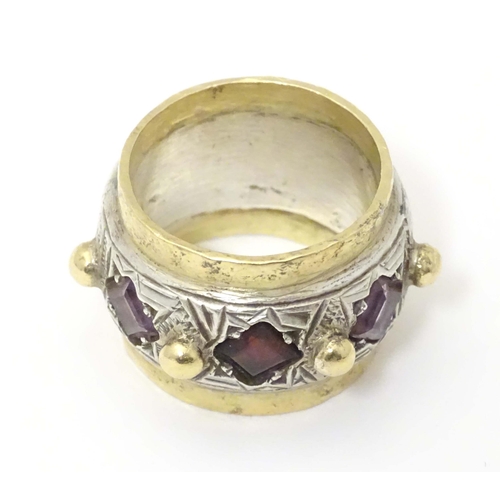 586 - A silver dress ring with gilt detail, set with amethysts and garnet, hallmarked London 1989, maker M... 