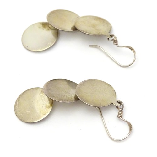 726 - A pair of .925 silver and white metal pendant earrings with three circular discs. Approx. 2