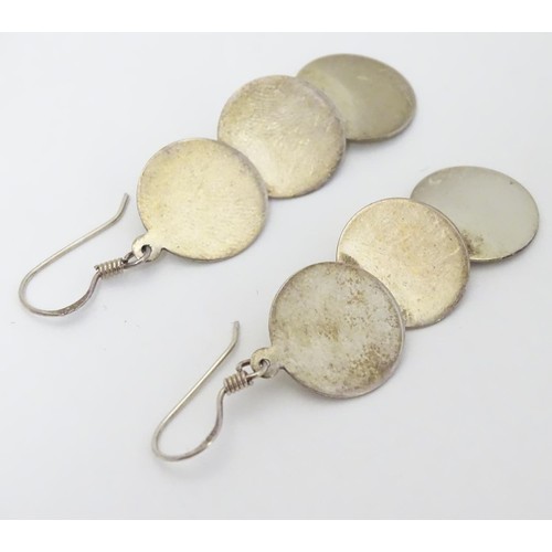 726 - A pair of .925 silver and white metal pendant earrings with three circular discs. Approx. 2