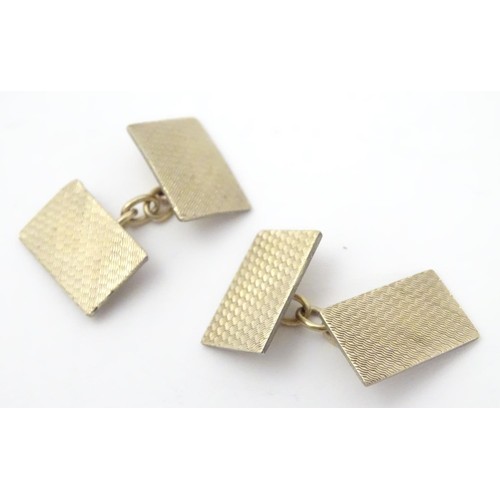 730 - A pair of silver gilt cufflinks with engine turned decoration.