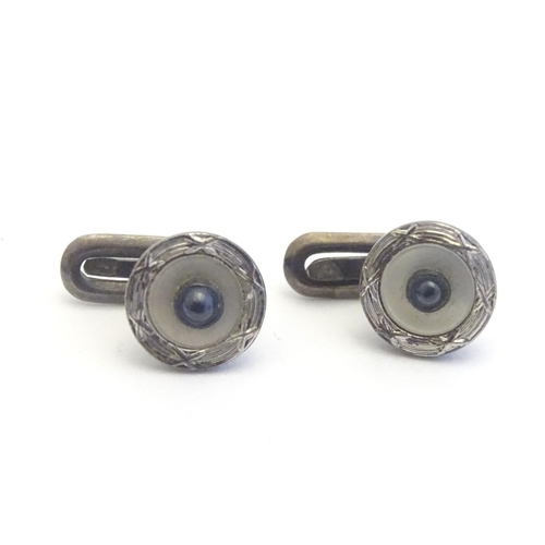 747A - A pair of dress studs marked 900 and set with sapphire cabochon to centre. 1/4