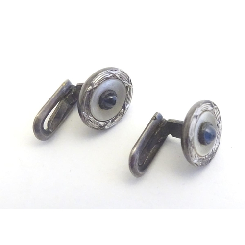 747A - A pair of dress studs marked 900 and set with sapphire cabochon to centre. 1/4