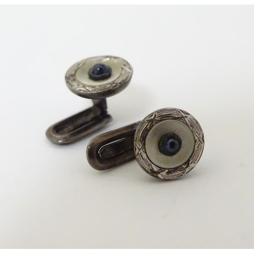 747A - A pair of dress studs marked 900 and set with sapphire cabochon to centre. 1/4