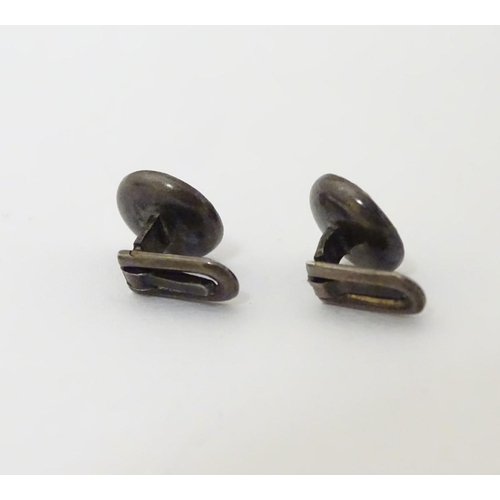 747A - A pair of dress studs marked 900 and set with sapphire cabochon to centre. 1/4