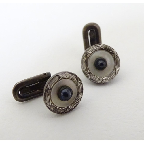 747A - A pair of dress studs marked 900 and set with sapphire cabochon to centre. 1/4