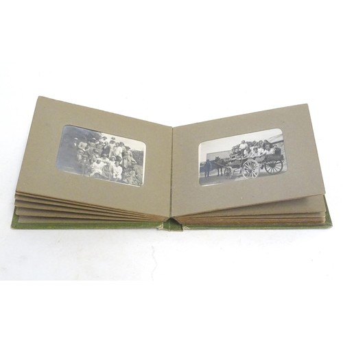 963 - An early 20thC photograph album with sepia and monochrome photos to include group shots in the count... 