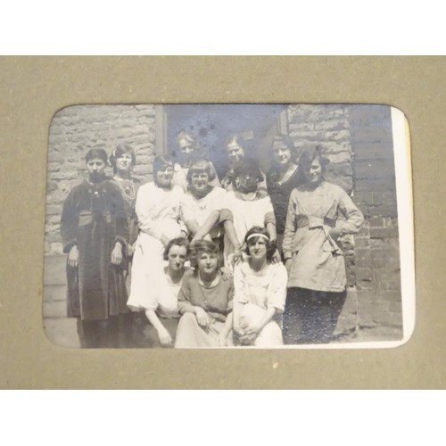 963 - An early 20thC photograph album with sepia and monochrome photos to include group shots in the count... 