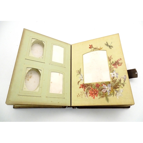 964 - A 20thC photograph album with leather bound cover and musical mechanism. The mounts decorated with f... 