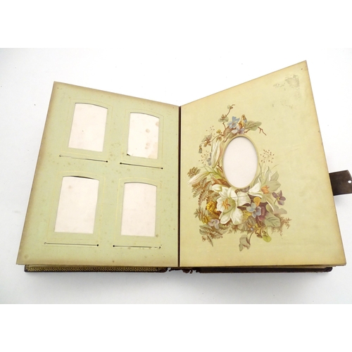 964 - A 20thC photograph album with leather bound cover and musical mechanism. The mounts decorated with f... 