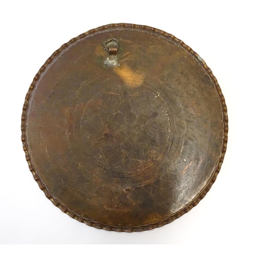 998 - An early 20thC copper charger with scalloped edge, central Arts & Crafts style floral motif and band... 