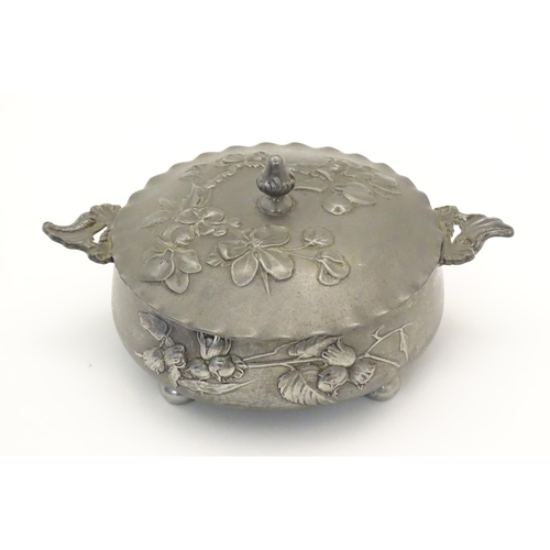 1001 - An Art Nouveau / Jugendstil twin handled pewter pot and cover with relief floral and foliage decorat... 