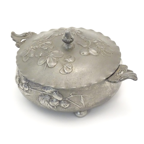 1001 - An Art Nouveau / Jugendstil twin handled pewter pot and cover with relief floral and foliage decorat... 