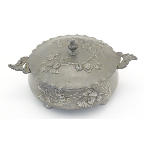 1001 - An Art Nouveau / Jugendstil twin handled pewter pot and cover with relief floral and foliage decorat... 