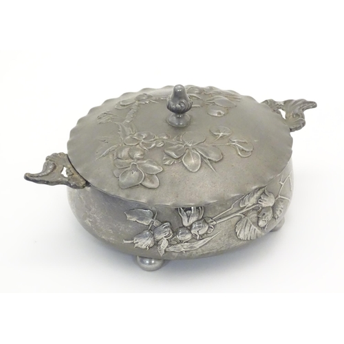 1001 - An Art Nouveau / Jugendstil twin handled pewter pot and cover with relief floral and foliage decorat... 