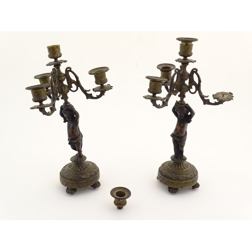 1005 - Two 19thC cast metal table candelabra / candelabrum the central bronze columns form as cherubs holdi... 