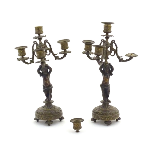 1005 - Two 19thC cast metal table candelabra / candelabrum the central bronze columns form as cherubs holdi... 