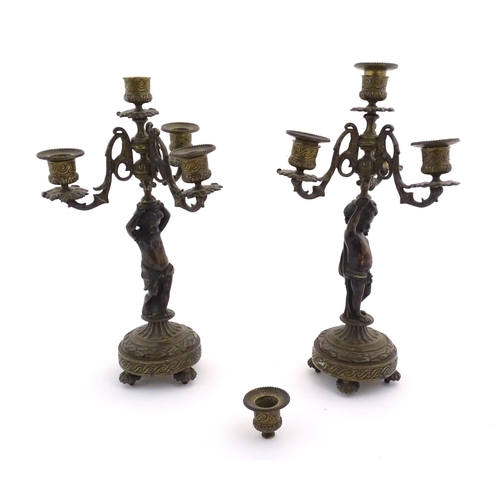 1005 - Two 19thC cast metal table candelabra / candelabrum the central bronze columns form as cherubs holdi... 