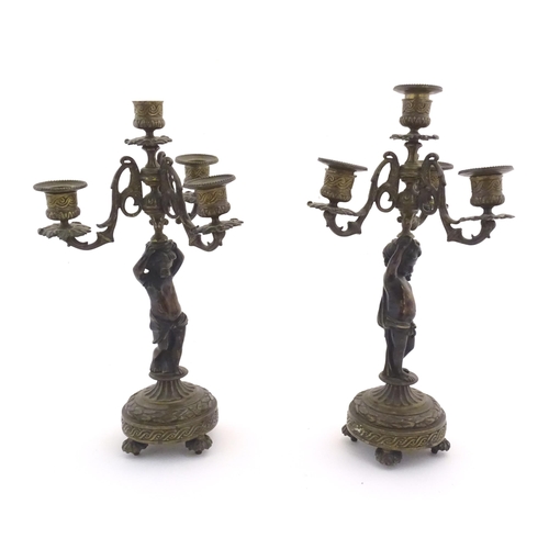 1005 - Two 19thC cast metal table candelabra / candelabrum the central bronze columns form as cherubs holdi... 