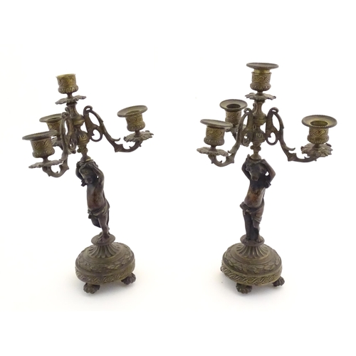 1005 - Two 19thC cast metal table candelabra / candelabrum the central bronze columns form as cherubs holdi... 