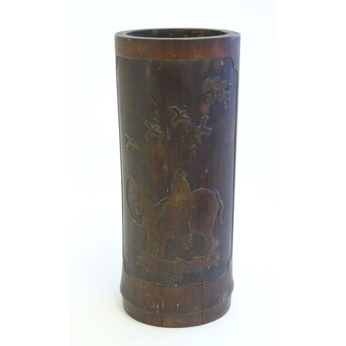 1022 - An Oriental carved bamboo vase depicting a figure on a water buffalo with birds. Approx. 10