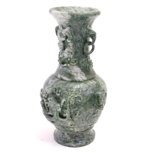 1030 - An Oriental jade coloured soapstone vase of three sectional baluster form decorated with stylised dr... 