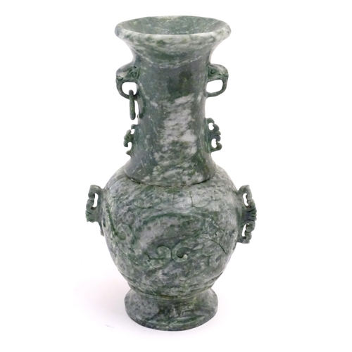 1030 - An Oriental jade coloured soapstone vase of three sectional baluster form decorated with stylised dr... 