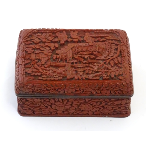 1038 - A Chinese cinnabar lacquer lidded box, the lid with carved detail depicting a landscape scene with t... 