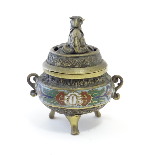 1045 - A Chinese cast brass three footed lidded censer, the body with twin handles and banded enamel detail... 