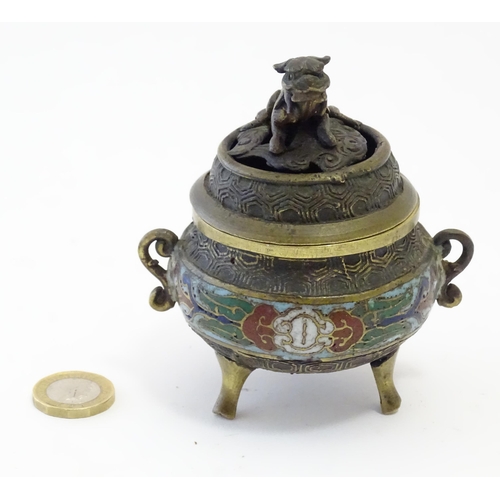 1045 - A Chinese cast brass three footed lidded censer, the body with twin handles and banded enamel detail... 