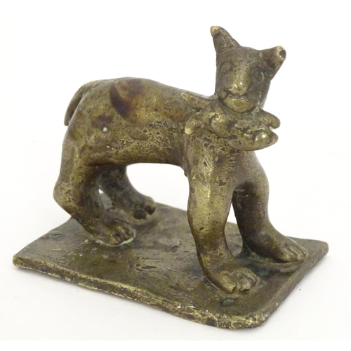 1052 - An 18th / 19th century naive bronze model of a standing cat with a fish, on a rectangular base. Appr... 