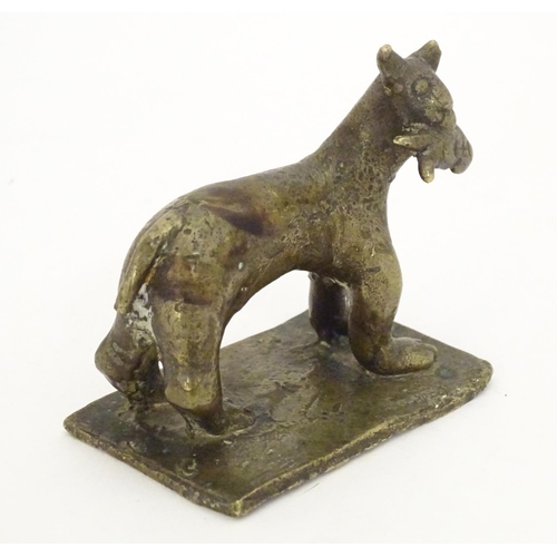 1052 - An 18th / 19th century naive bronze model of a standing cat with a fish, on a rectangular base. Appr... 