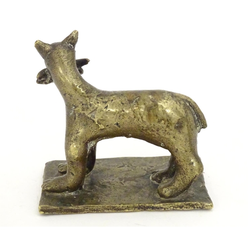 1052 - An 18th / 19th century naive bronze model of a standing cat with a fish, on a rectangular base. Appr... 