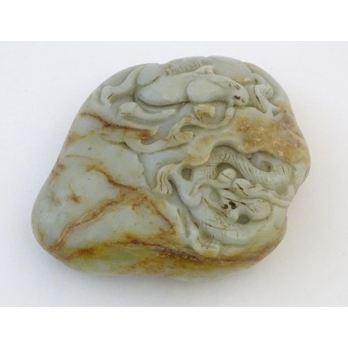 1053 - A Chinese jade scroll weight with carved decoration depicting a dragon and horse. Approx. 5