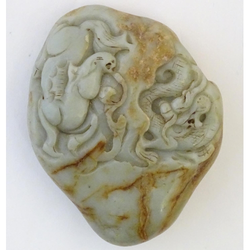 1053 - A Chinese jade scroll weight with carved decoration depicting a dragon and horse. Approx. 5