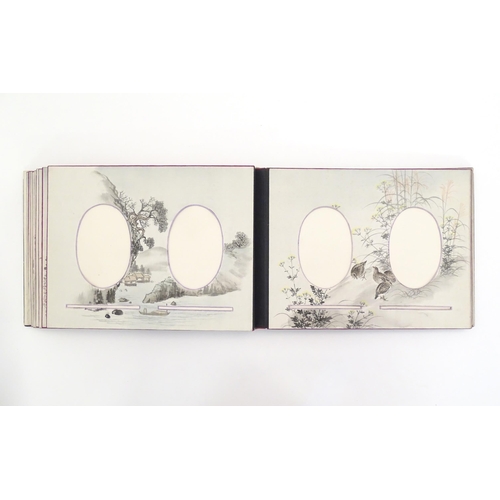 1054 - A Japanese photograph album with lacquered boards, the cover decorated with figures travelling by ha... 