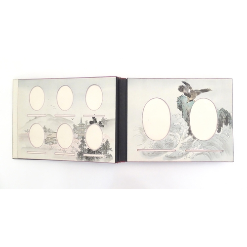 1054 - A Japanese photograph album with lacquered boards, the cover decorated with figures travelling by ha... 