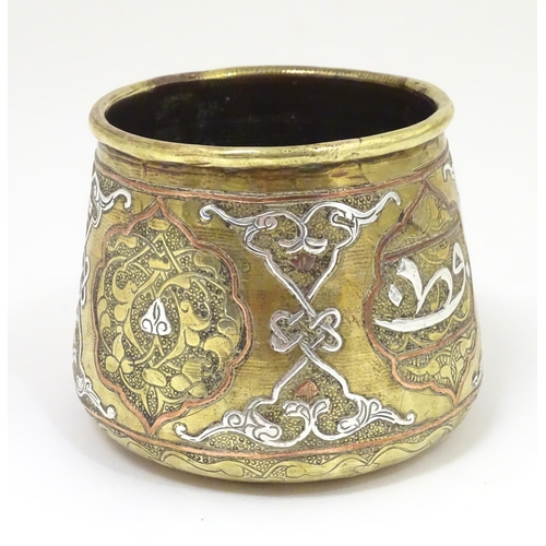 1055 - An early 20thC Middle Eastern brass pot of tapered form with engraved detail and inlaid white metal ... 