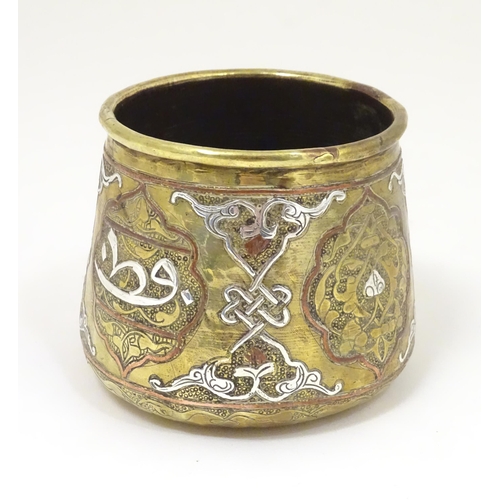 1055 - An early 20thC Middle Eastern brass pot of tapered form with engraved detail and inlaid white metal ... 