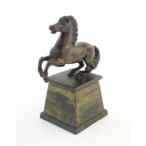 1124 - An early 20thC cast model of a rearing horse, on a tapered plinth base. Approx. 5 3/4